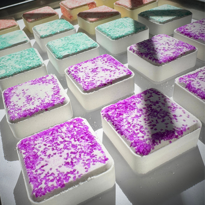 Colorful shower steamer squares  with colorful sea salt on a white background