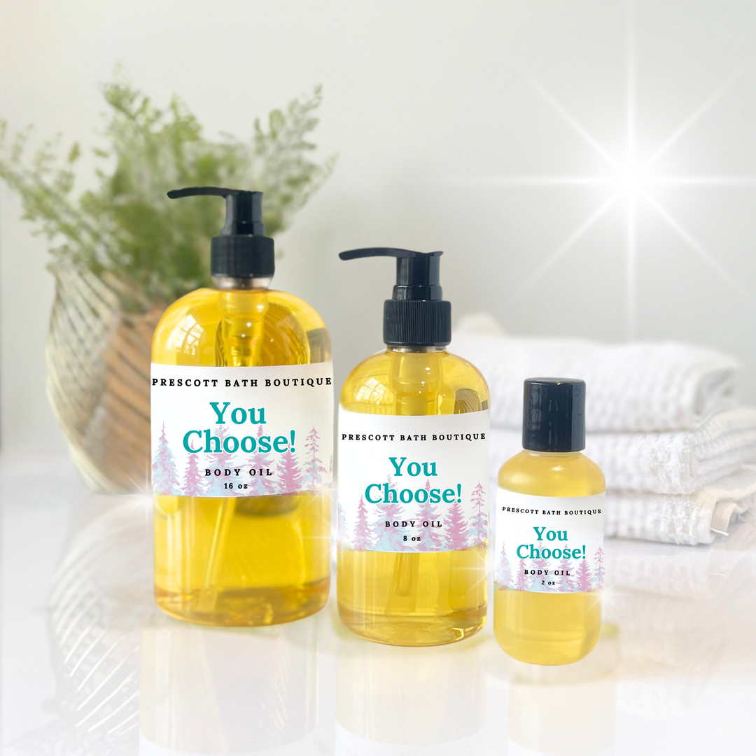 Three bottles of Prescotty Bath Boutique body oil on a white surface with a blurred background.